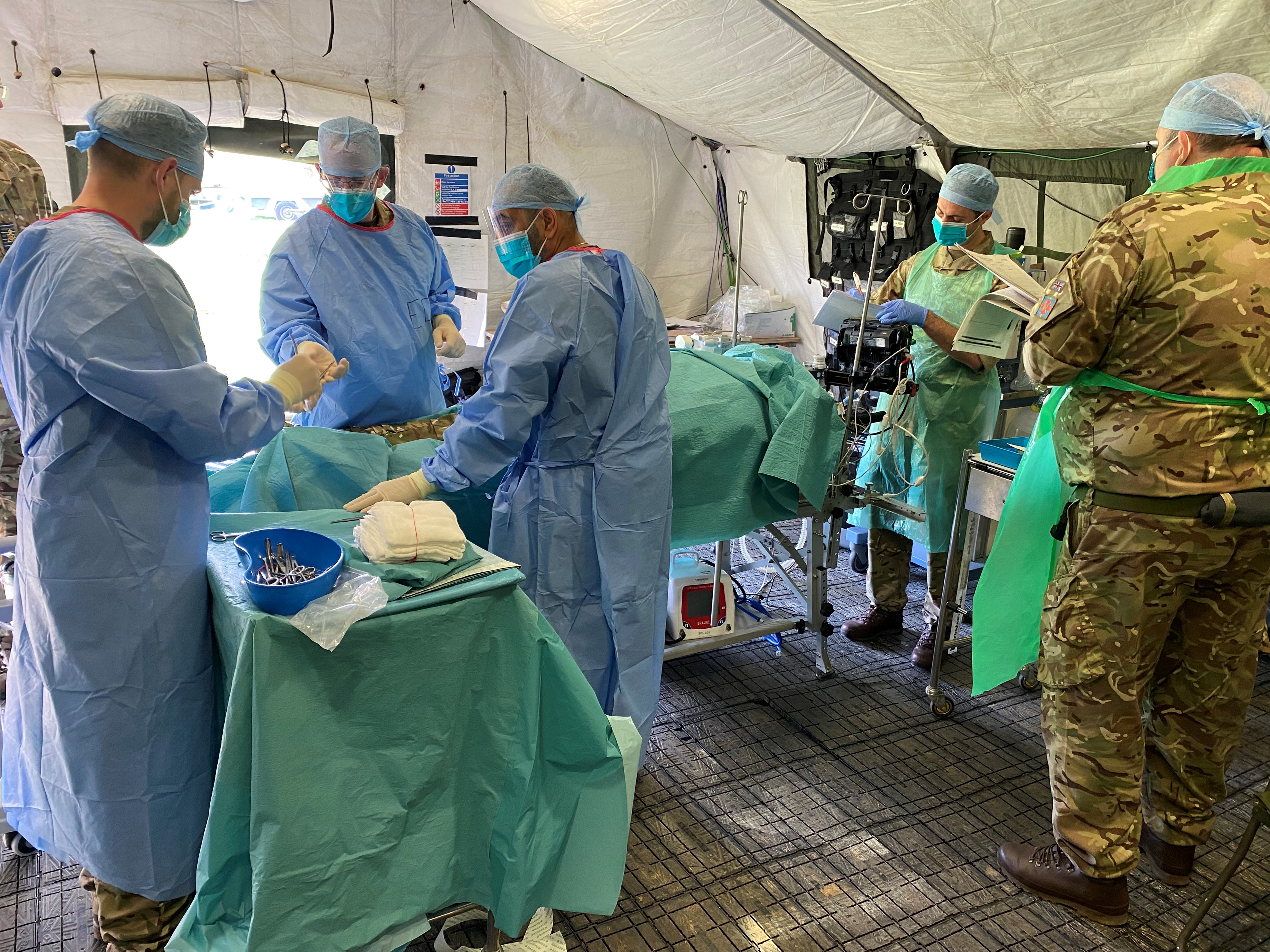 Photo - Tactical Medical Wing on Exercise Athena Dragon 23. Image shows a hospital theatre exercise scenario, with surgeons, nurses and technical personnel